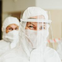 审校人员在纸质资料上用笔标注编码格式要点，桌面有放大镜与便签，氛围专注安静